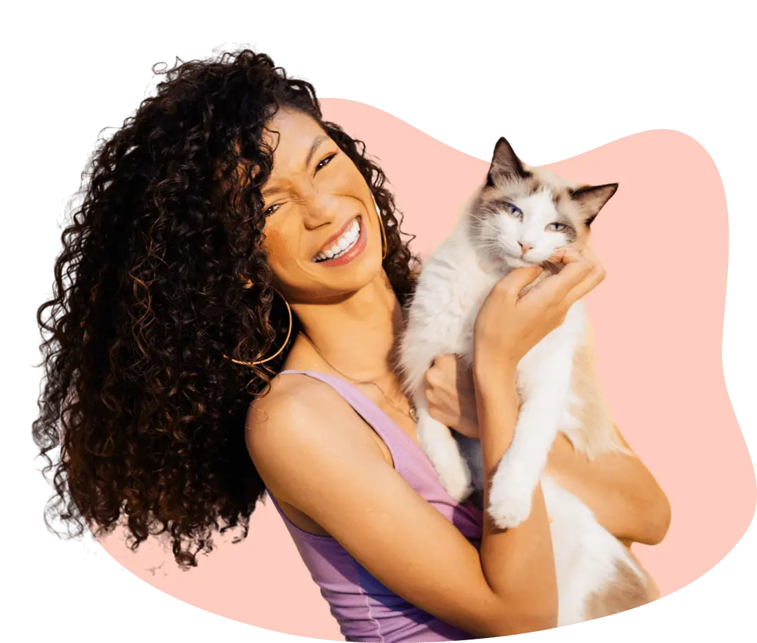 woman holding cat pink bg